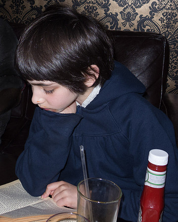 Leah reading while eating.
